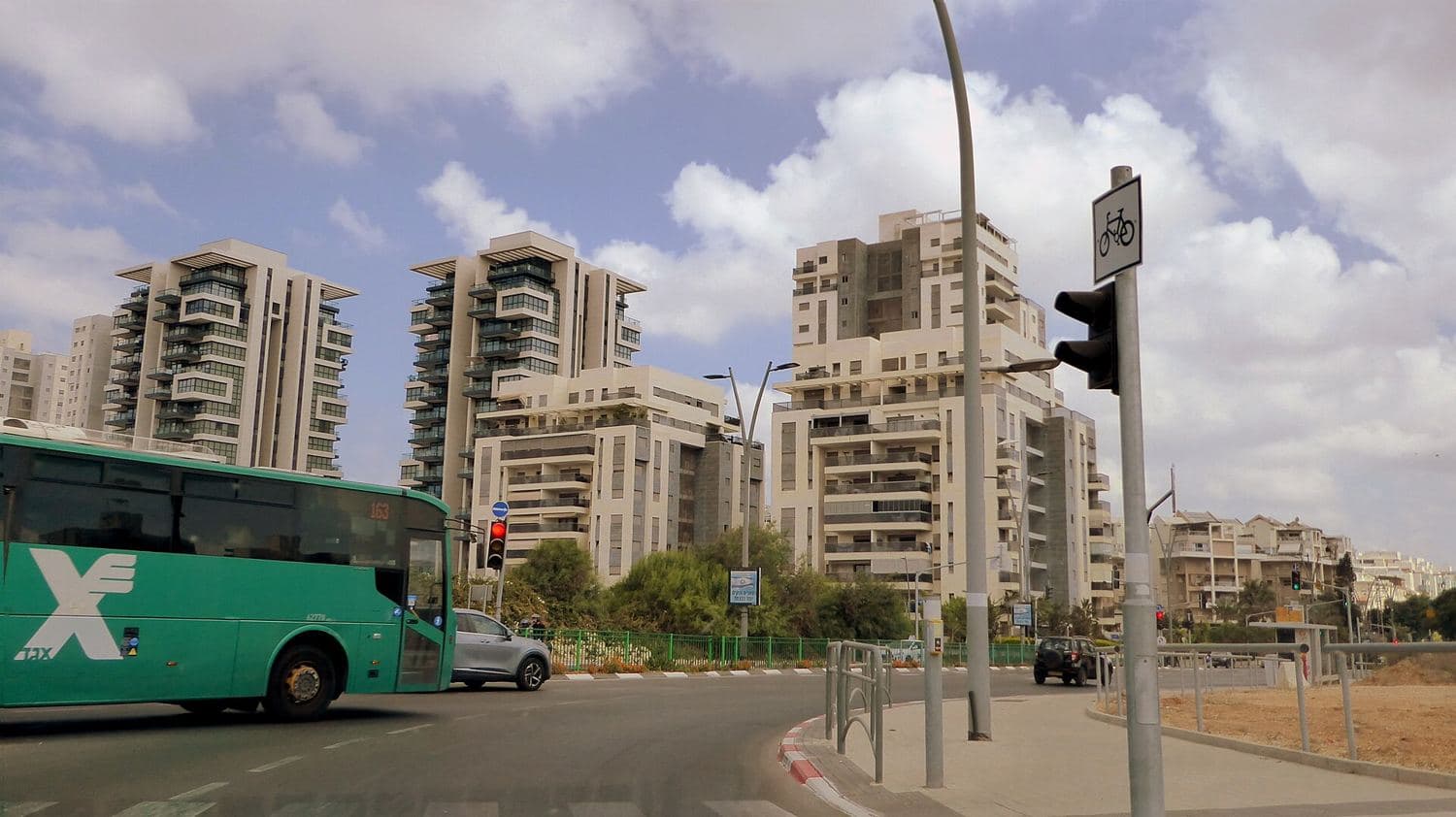 בנייני מגורים חדשים וכביש עם אוטובוס